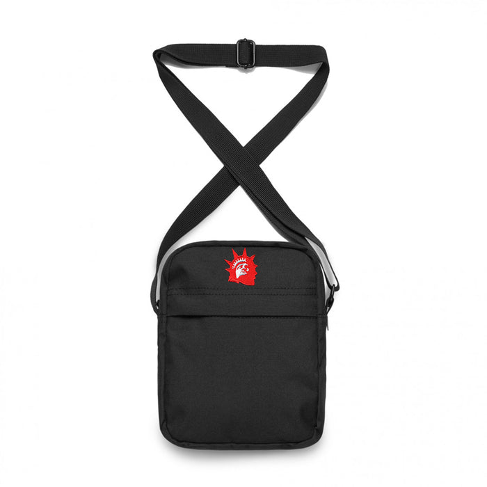 Trophy Eyes black shoulder bag with an adjustable strap, featuring a small red Statue of Liberty head graphic on the upper front. The bag has a simple, minimalist design.