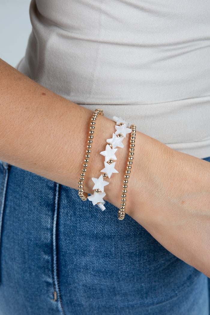 Star-shaped bracelet on a person's wrist with a neutral background