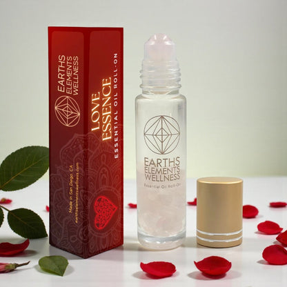 Earth's Elements Wellness Love Essence essential oil roll-on with packaging and rose petals on a light background