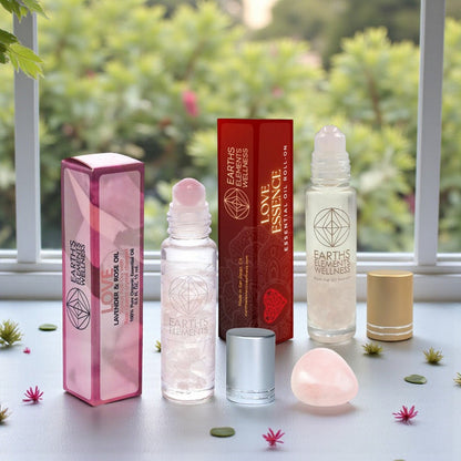 Love Roll-Ons plus a rose quartz tumble on a table with a blurred green outdoor background