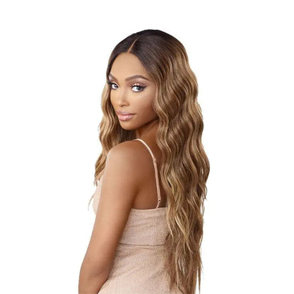 SENSATIONNEL butta lace unit 29 wig long wavy honey blonde with dark roots and center part on model
