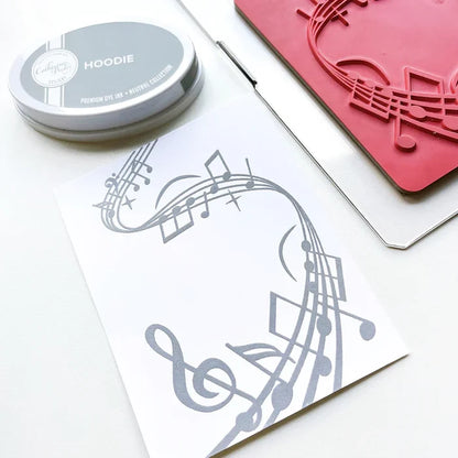 Catherine Pooler - Background Stamp - On Staff. Add some dancing notes to your card background with the On Staff Background Stamp. This red rubber stamp features a winding music staff pattern with notes and musical icons. Available at Embellish Away located in Bowmanville Ontario Canada.