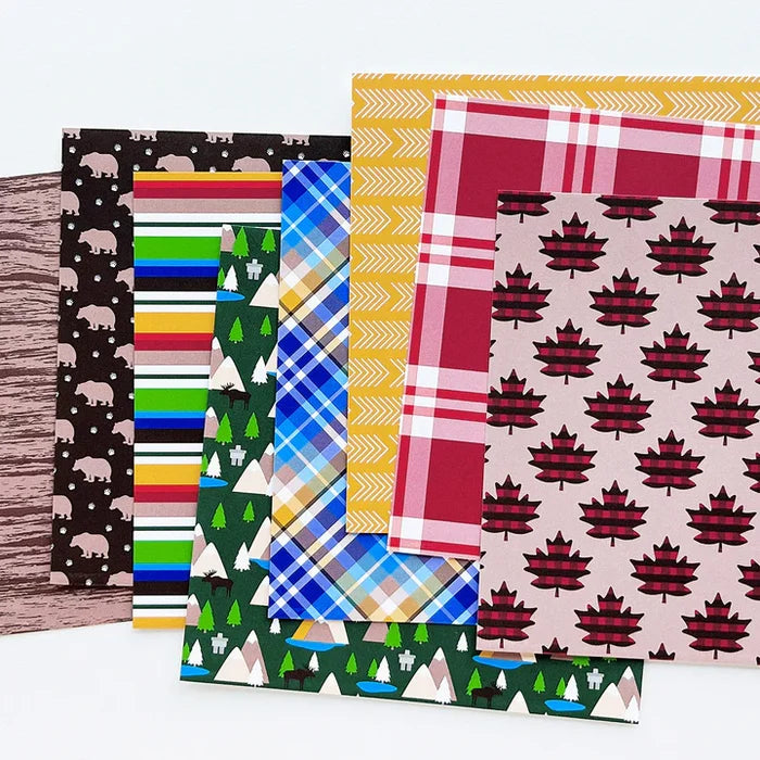 Catherine Pooler - Patterned Paper - Moose Crossing. Oh the beauty of the land and heritage of Canada! The Moose Crossing Patterned Paper celebrates this with patterns including moose, mountains, inuksuks, bears, woodgrain and maple leaves. Available at Embellish Away located in Bowmanville Ontario Canada.