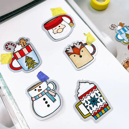 Catherine Pooler - Stamp & Die Set - Holiday Mug. From the makers of the original Mug Shots Stamp Set comes Holiday Mug Shots Stamps and coordinating dies! Features all your favorite winter friends- Santa, Rudolf, Snowman and even the Gingerbread man. Available at Embellish Away located in Bowmanville Ontario Canada.