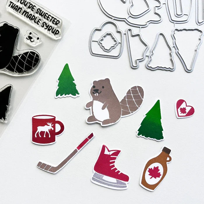 Catherine Pooler - Stamp & Die Set - O Canada. This one is sweeter than maple syrup, eh? Here's too the beautiful country of Canada! This fun icons stamp & die set and it's has images of maple syrup, hockey, a Mountie hat and a hot cup of "Timmies" Available at Embellish Away located in Bowmanville Ontario Canada.