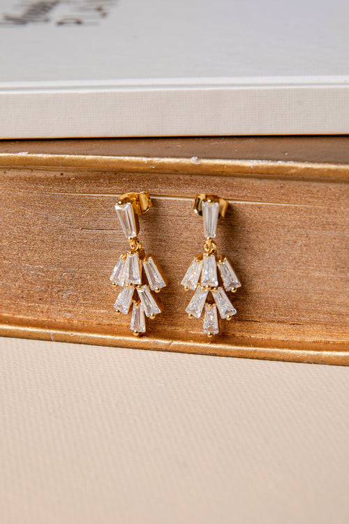 Pair of diamond earrings on a wooden surface