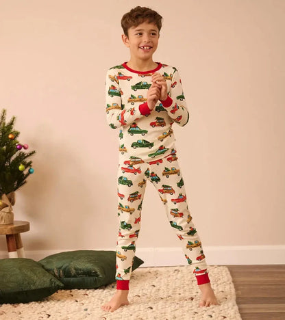 Boy wearing Hatley Christmas Cars pajamas with soft organic cotton and snug-fitting comfort.