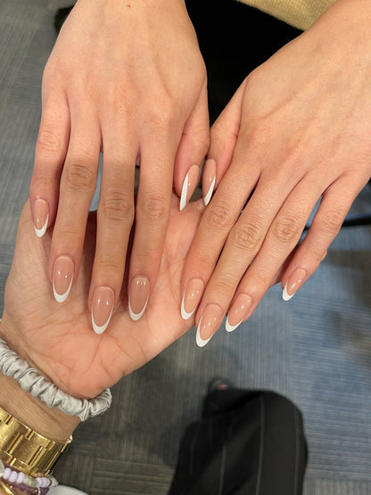 Classic French - Press-On | Medium | Almond showing hands with medium almond false nails in neutral peachy pink base and white tips manicure