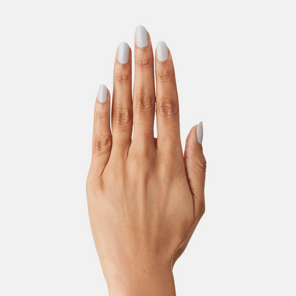 Hand with nails painted in soft misty grey using Cloudy Skies nail polish for a cozy at-home mani.