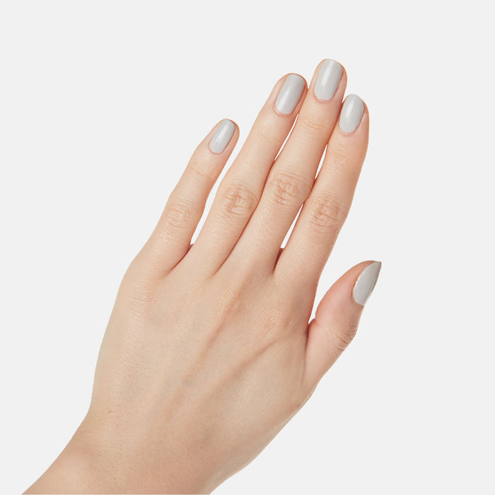 Hand showing nails painted with Cloudy Skies long-lasting polish in a soft misty grey for an at-home mani