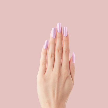 Cockatoo - Press-On | Long | Squoval long false nails in glowing lavender pink shade on hand against pale pink background