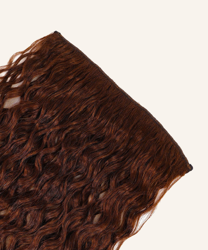 Curly Perfect Crown Hair Extensions by Perfect Locks in Toffee Blonde Highlights (4/27) are arranged against a simple, light backdrop.#color_chocolate-brown-(3)