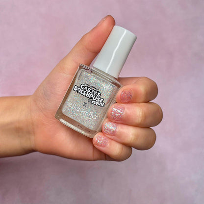 Gabby's Dollhouse silver glitter nail polish on a light skin tone, holding the bottle