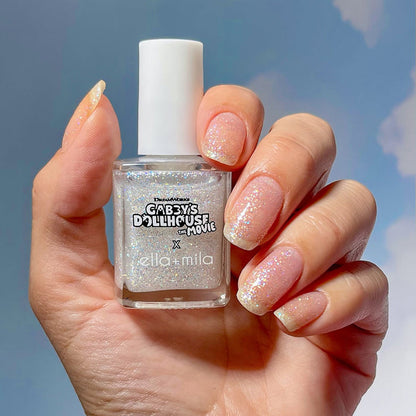 Gabby's Dollhouse silver glitter over pink nails on a light skin tone, holding the bottle