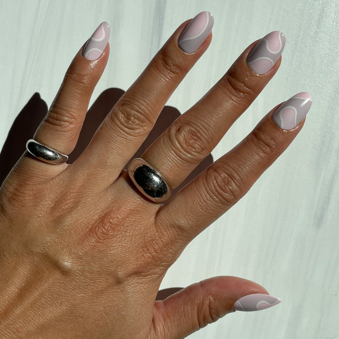 Groovy Swirl - Press-On | Medium | Oval showing medium oval false nails with pink and lavender swirl mani on hand in natural light