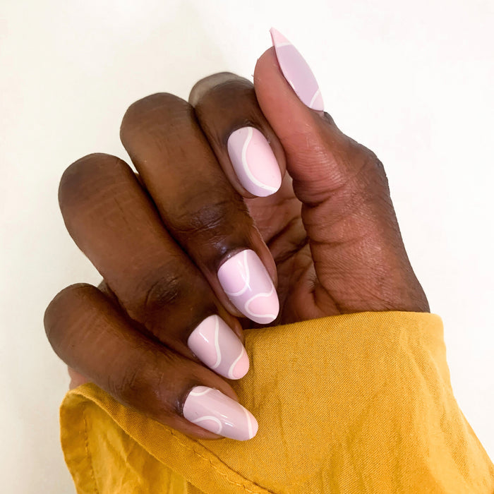 Groovy Swirl - Press-On | Medium | Oval showing medium oval press-on nails with pink and lavender swirl manicure on hand outdoors