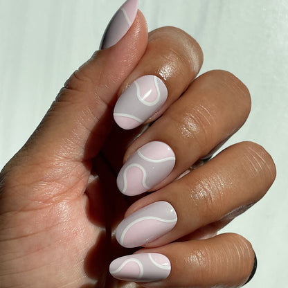 Groovy Swirl - Press-On | Medium | Oval showing hand with medium oval press-on nails in pink and lavender swirled mani