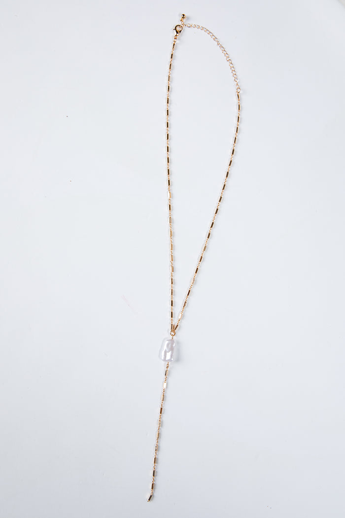 Long necklace with a clear pendant on a light gray background
