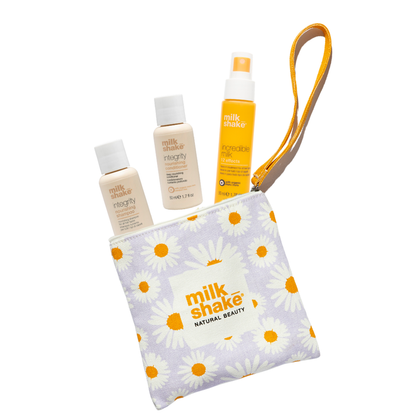 Set of milk_shake integrity shampoo, conditioner and incredible milk in a pouch with daisy pattern on a white background