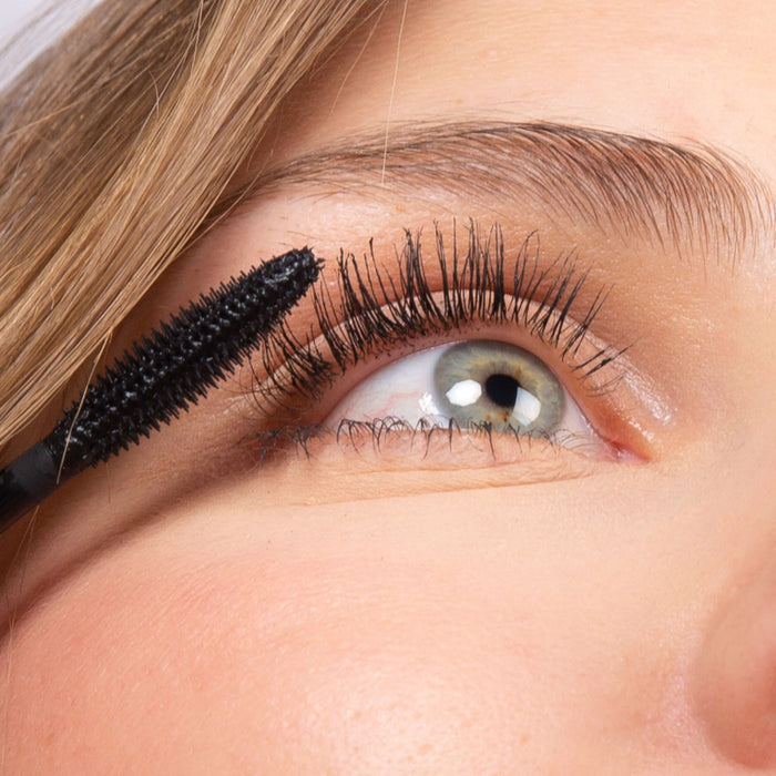Application du mascara Volume Boost naturel noir sur les cils, gros plan – Charlotte Bio