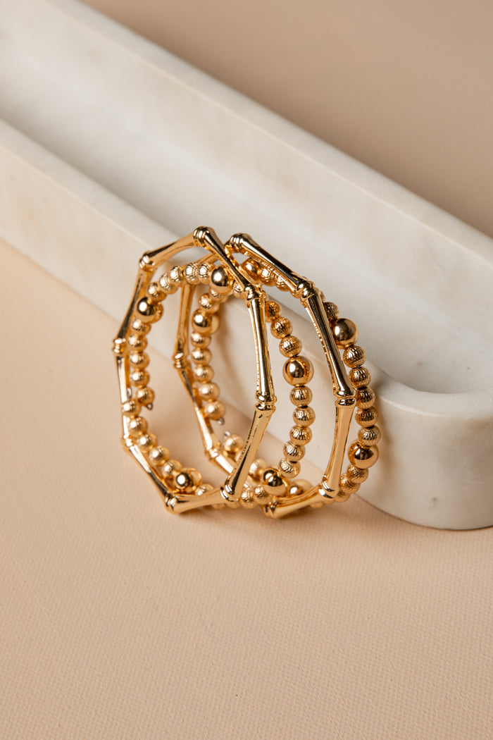 Gold ring with beaded design on a beige surface