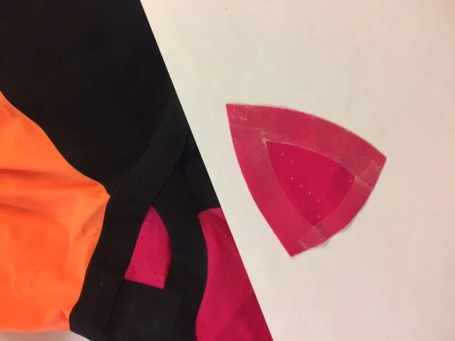 AK race suit repair service, showing a close-up of a race suit being repaired with professional stitching and fabric details.
