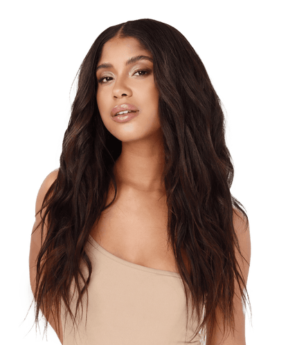 A woman with long, dark brown Relaxed Straight Perfect Crown Hair Extensions by Perfect Locks in a beige one-shoulder top poses confidently against a plain white background, looking at the camera.