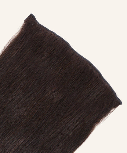 A close-up of Relaxed Straight Perfect Crown Hair Extensions in natural black by Perfect Locks against a light background.#color_natural-black-(1B)