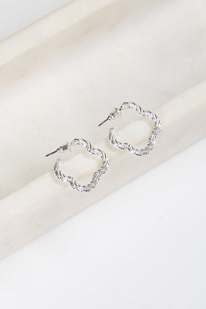 Silver hoop earrings on a white surface