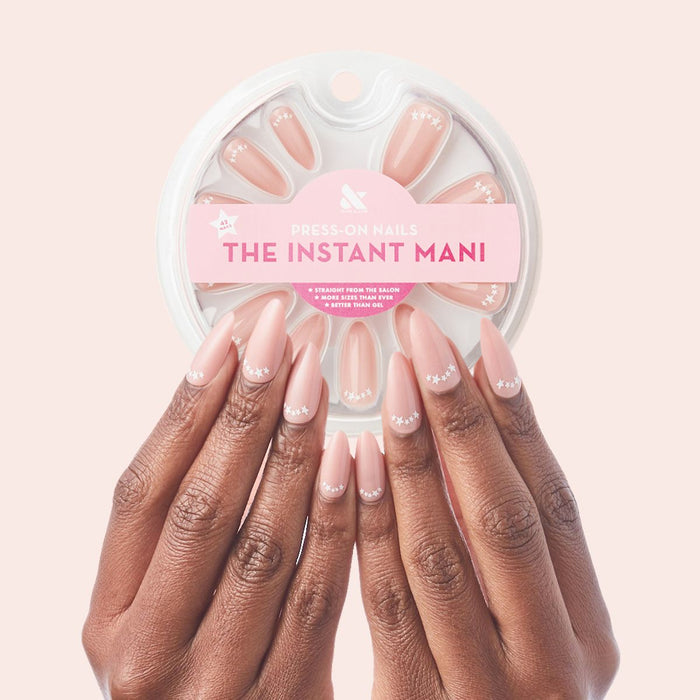 Star Halfmoon - Press-On | Long | Almond showing hands with long almond press-on nails in soft nude with white star halfmoon design manicure