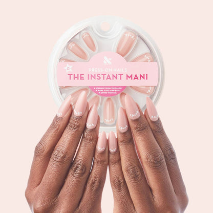 Star Halfmoon - Press-On | Long | Almond showing hands with long almond press-on nails in soft nude with white star halfmoon design manicure