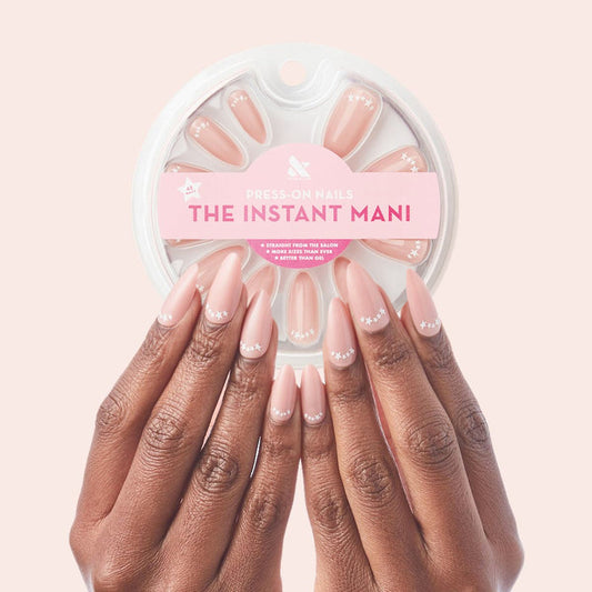 Star Halfmoon - Press-On | Long | Almond showing hands with long almond press-on nails in soft nude with white star halfmoon design manicure