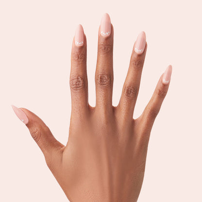 Star Halfmoon - Press-On | Long | Almond showing hand with long almond press-on nails in soft nude and delicate star halfmoon design manicure