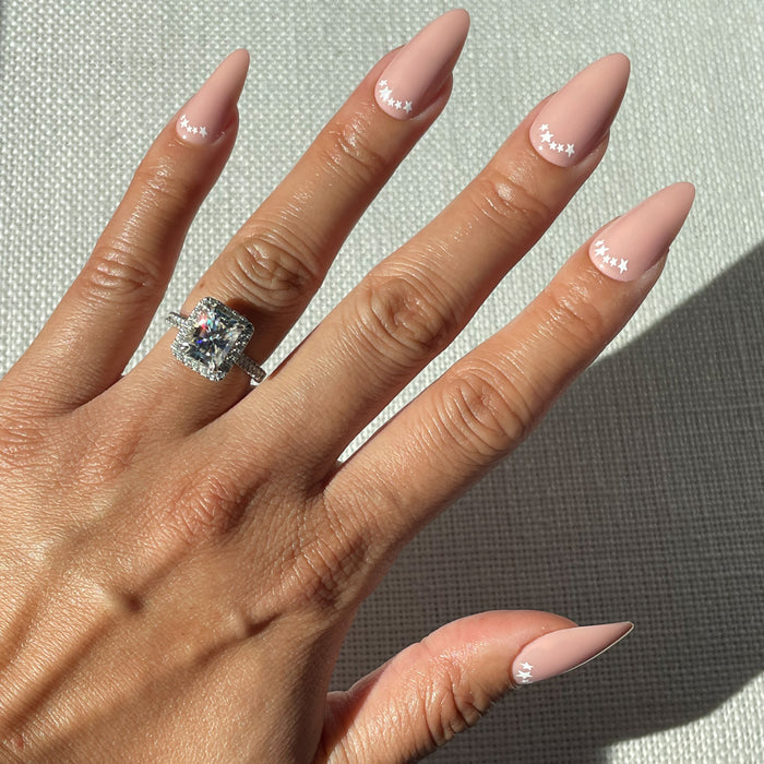 Star Halfmoon - Press-On | Long | Almond showing hand with long almond press-on nails in soft pink with white star halfmoon manicure
