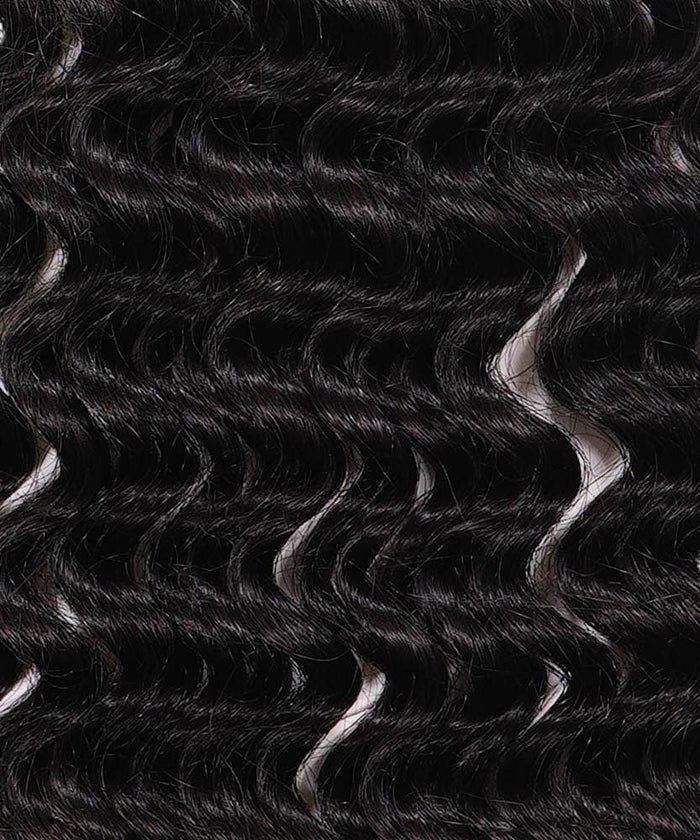 Close-up of shiny, dark brown or black wavy hair with defined loose curls in a uniform pattern, highlighting natural texture.