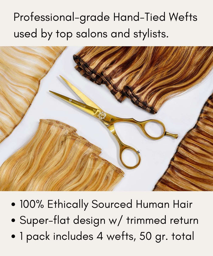 Gold scissors rest on hand-tied wefts of blonde and brunette human hair extensions, highlighting features and ethical sourcing.