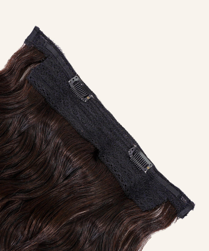 Close-up of Perfect Locks Wavy Perfect Crown Hair Extensions in Golden Brown  with black lace bands and small comb clips, laid flat on a light beige background.#color_natural-black-(1B)