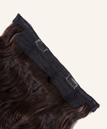 Close-up of Perfect Locks Wavy Perfect Crown Hair Extensions in Golden Brown  with black lace bands and small comb clips, laid flat on a light beige background.#color_natural-black-(1B)