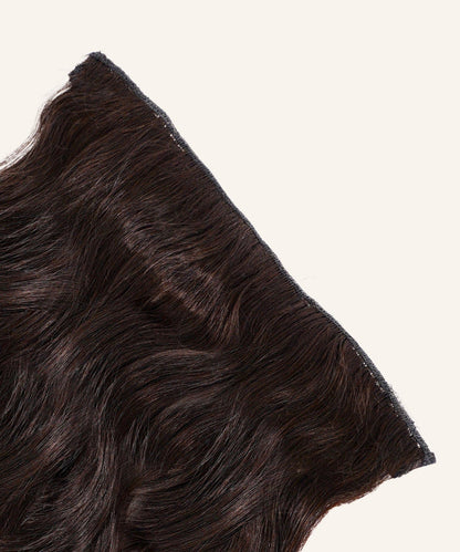 A close-up of Wavy Perfect Crown Hair Extensions by Perfect Locks in Honey Blonde , with visible wefts against a light background.#color_natural-black-(1B)